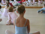 Balletelever sidder på gulvet