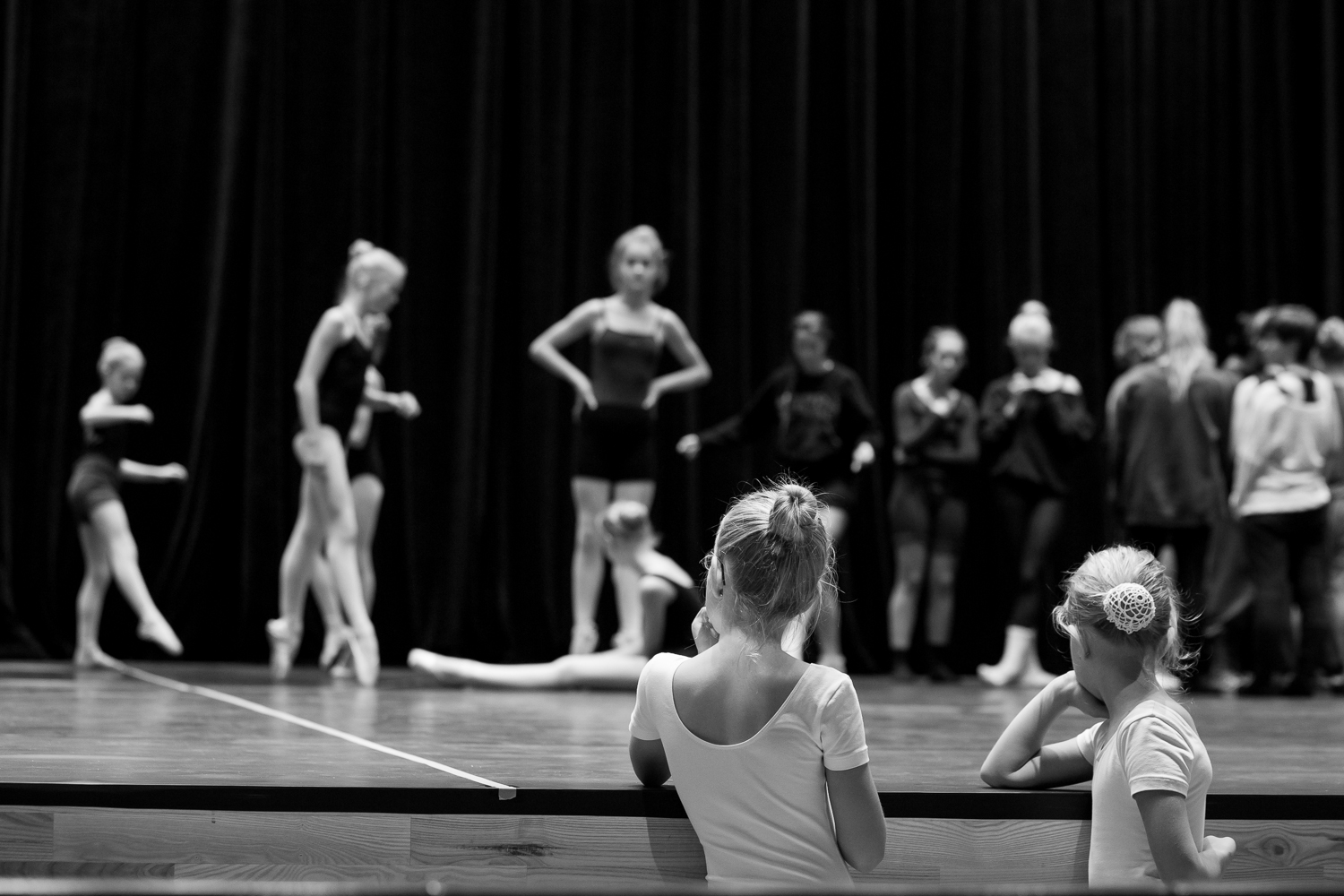 To balletbørn betragter større elever på scenen
